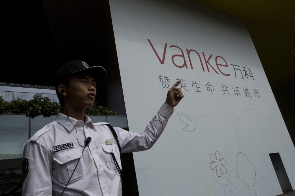 A security guard gestures in front of Vanke’s headquarters in Shenzhen. Vanke has proposed delaying repayment on a yuan-denominated bond for the first time, causing the prices of some its dollar-denominated bonds to fall into distressed territory. Photo: Reuters
