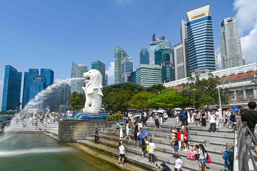 People take pictures next to the Merlion statue at the Marina Bay waterfront in Singapore. Photo: AFP