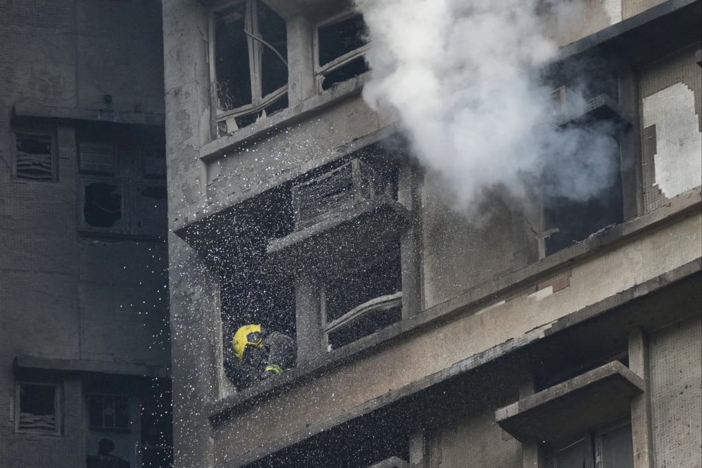 A firefighter works in a flat in one of the eight blocks of Wang Fuk Court in Tai Po on the afternoon of November 26. Photo: Karma Lo