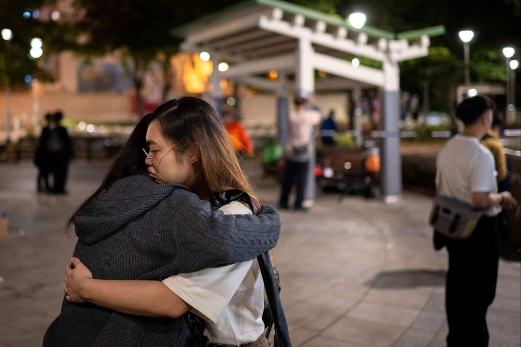 People hug at a makeshift memorial outside the Wang Fuk Court apartment blocks in the aftermath of the deadly fire in Hong Kong’s Tai Po district, on December 1. Photo: AFP