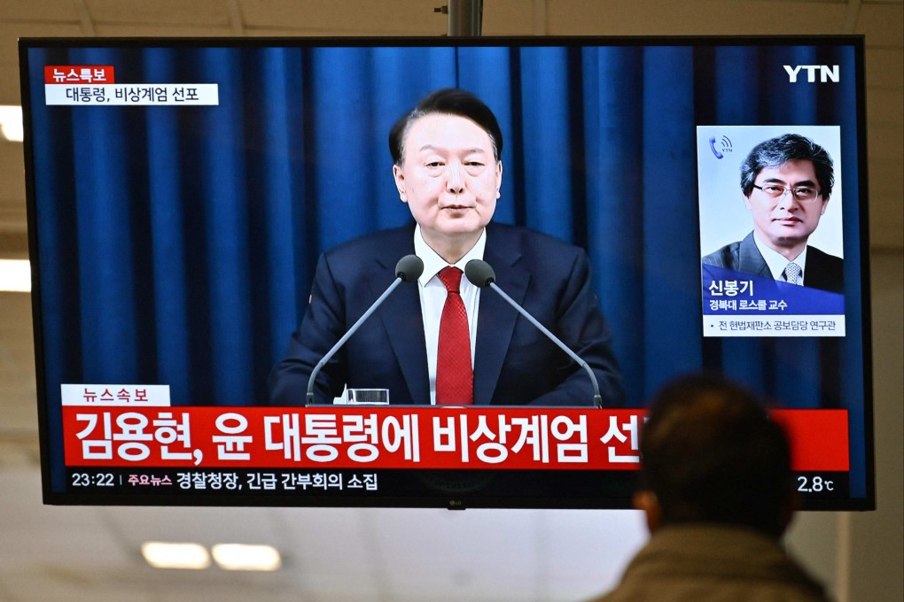 A man watches South Korea’s former president Yoon Suk-yeol speak during a news broadcast on a television at a train station in Seoul, after he declared emergency martial law. Photo: AFP