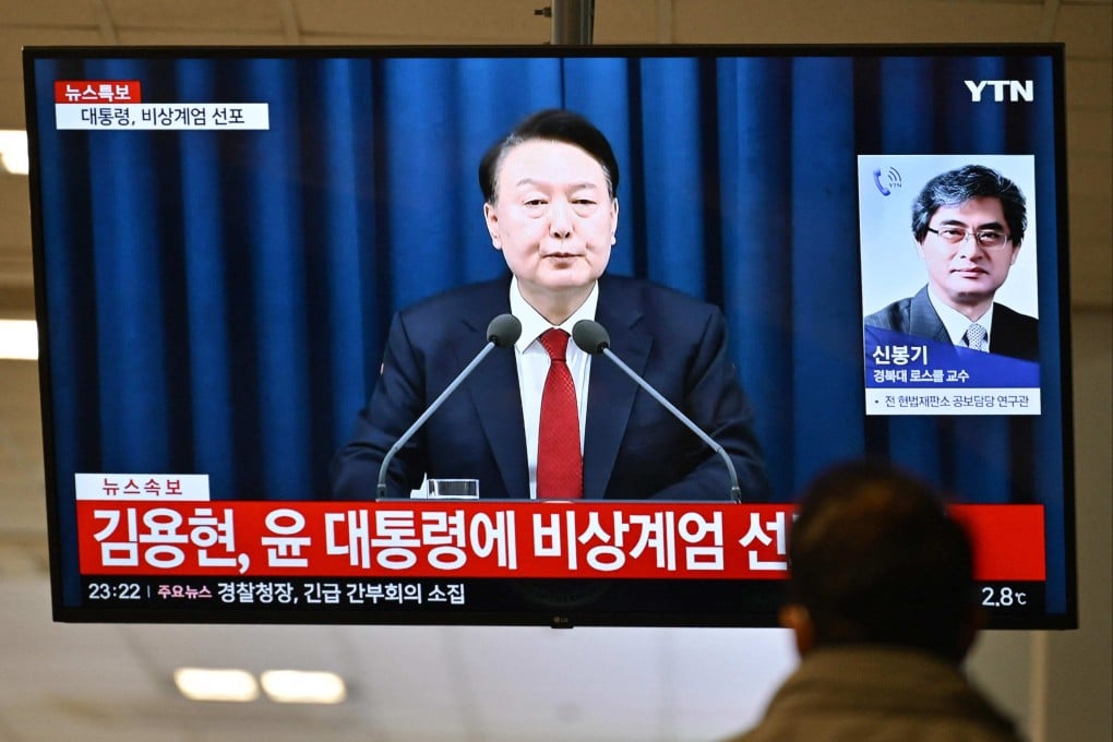 A man watches South Korea’s former president Yoon Suk-yeol speak during a news broadcast on a television at a train station in Seoul, after he declared emergency martial law. Photo: AFP