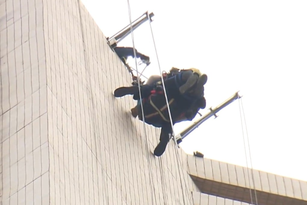 A firefighter abseils down to the gondola to rescue one of the workers. Photo: Now TV News