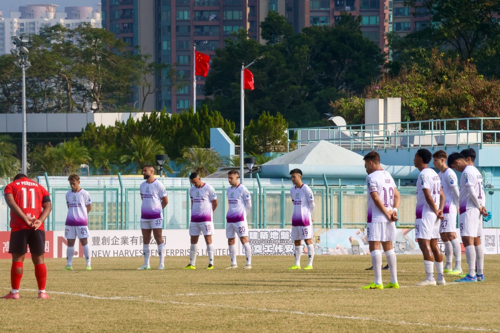 Players observe a minute’s silence before the Premier League match between Tai Po (in white) and North District. Photo: Jonathan Wong