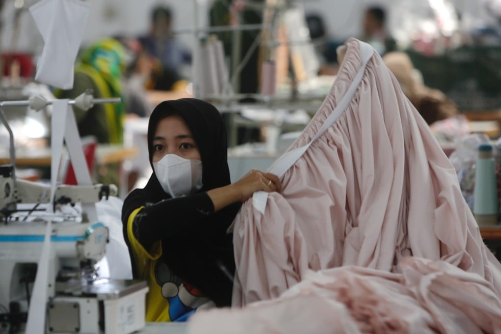 A worker holds a piece of clothing at a factory in Depok, Indonesia, on April 25, 2022. Photo: EPA-EFE/ADI WEDA