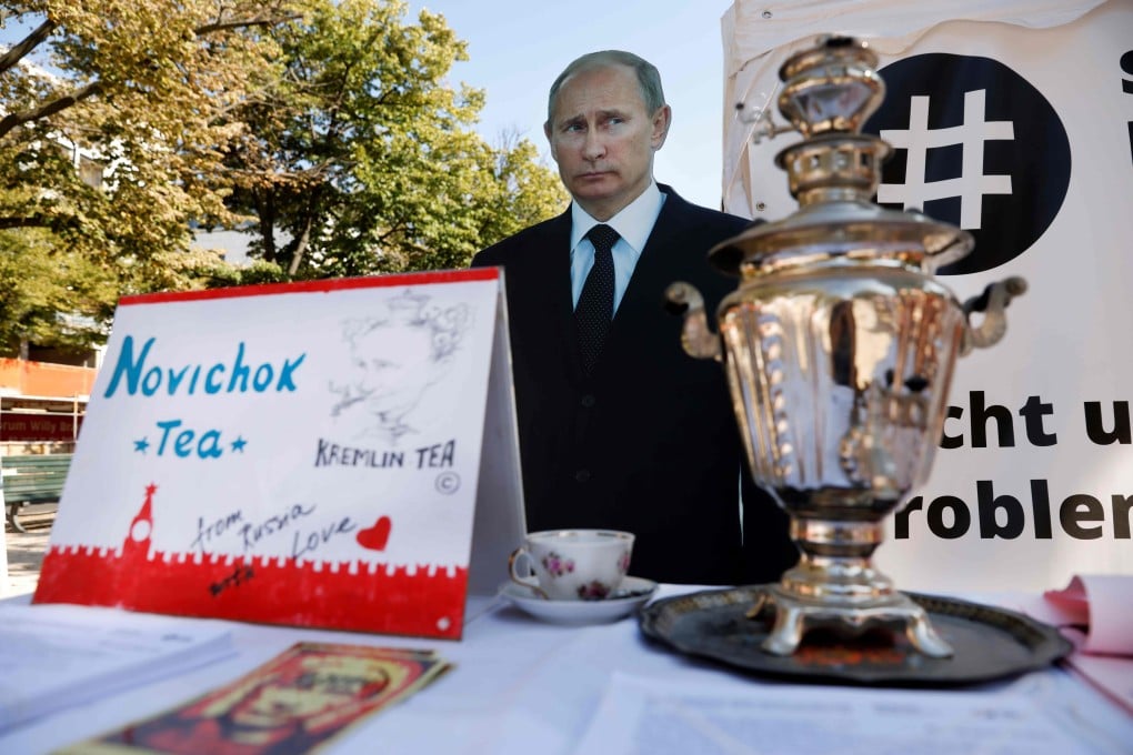 A mock offer of “Novichok Tea” sits in front of an effigy of Russian President Vladimir Putin outside the Russian embassy in Berlin in 2020. Photo: AFP