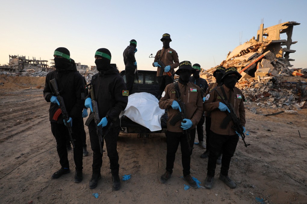 Hamas and Islamic Jihad militants wait for Red Cross members to receive a body before it is handed over to Israel in Beit Lahiya, in the northern Gaza Strip, on Wednesday. Photo: Reuters