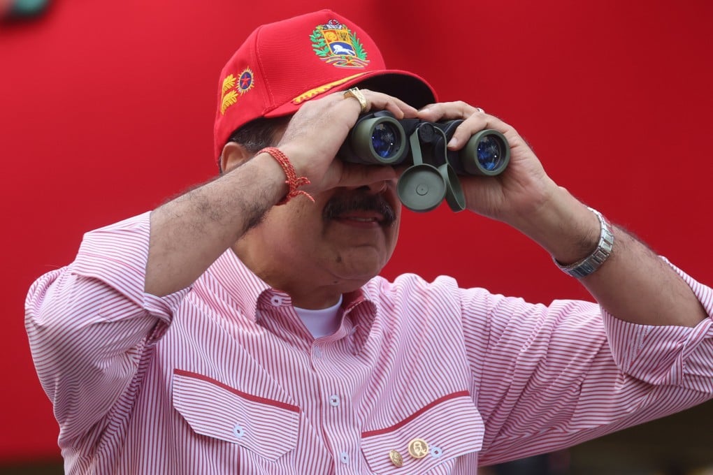 Venezuelan President Nicolas Maduro looks through binoculars during a rally in Caracas on Monday. Photo EPA