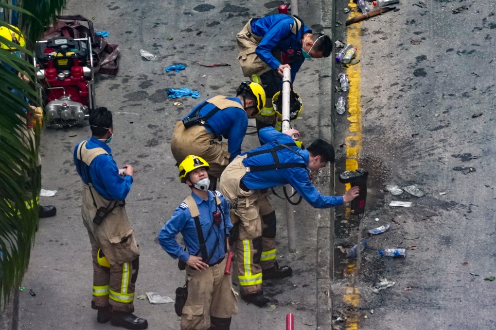 Firefighters are seen outside the Tai Po fire on December 4. Photo: Karma Lo