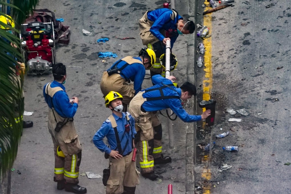 Firefighters are seen outside the Tai Po fire on December 4. Photo: Karma Lo
