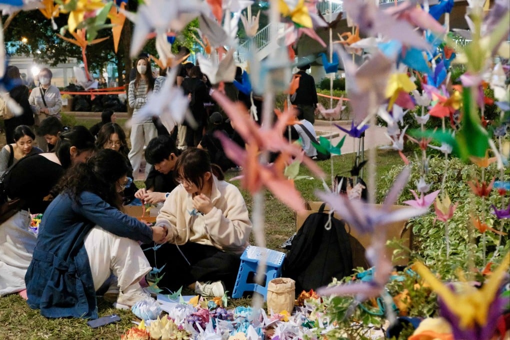 Mourners fold paper cranes during a memorial event held outside the Wang Fuk Court apartment blocks on December 3, in the aftermath of the deadly November 26 fire in Hong Kong’s Tai Po district. Photo: AFP