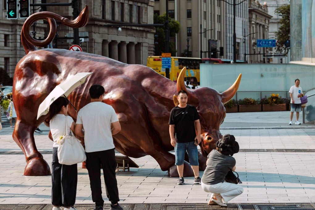 People take photos by the bull statue in Shanghai, on August 7. Photo: EPA
