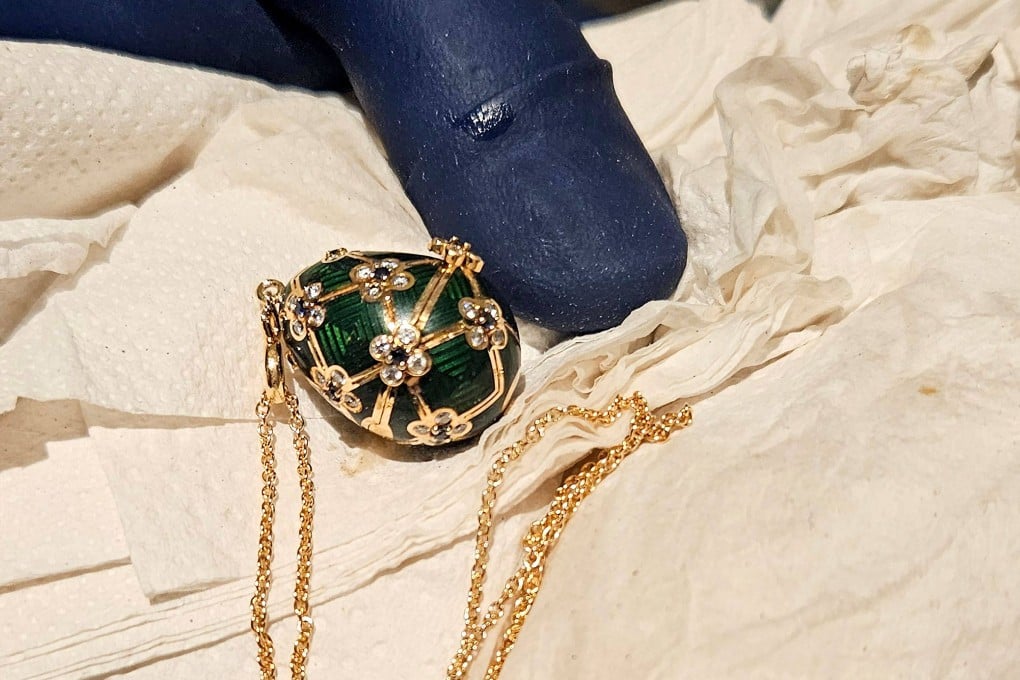 An officer displays a recovered diamond-encrusted green Faberge egg on Friday in Auckland, New Zealand after keeping a six-day watch over the thief accused of swallowing it. Photo: New Zealand Police/AFP