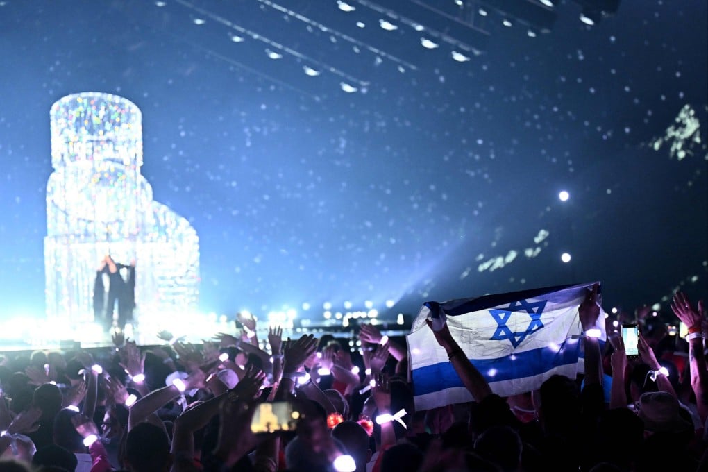 A person waves Israel’s national flag while watching Israeli singer Yuval Raphael perform at the 2025 Eurovision Song Contest. Photo: AFP