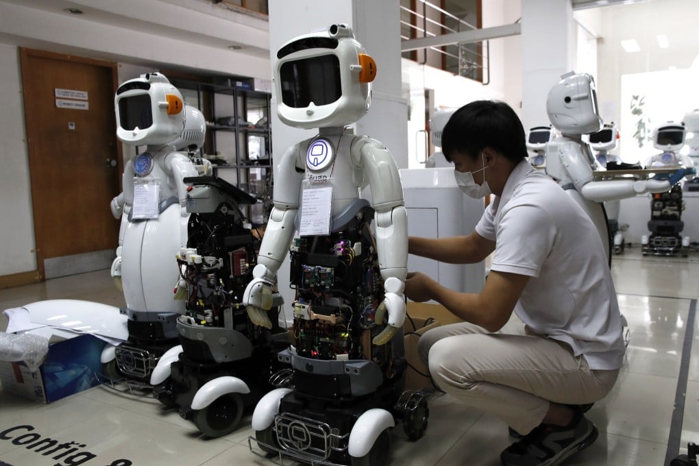 A Thai engineer services AI-powered healthcare robots in Bangkok, Thailand, in 2023. Photo: EPA-EFE