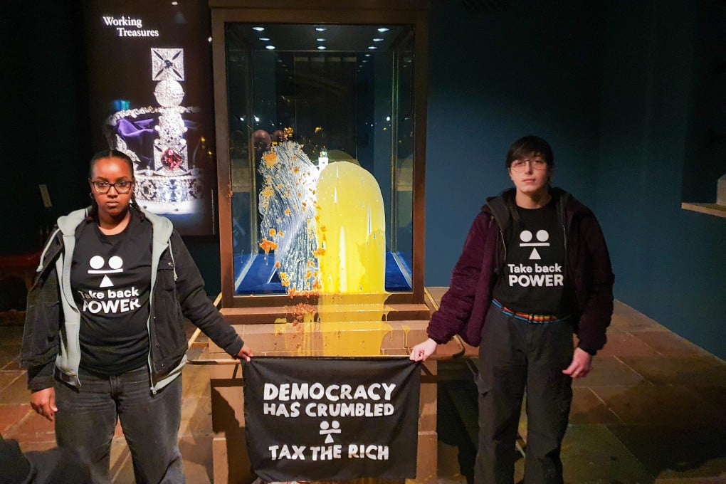 Two supporters of Take Back Power group after dessert was thrown over the Crown Jewels in the Tower of London. Four protesters were arrested for throwing food at the display case. Photo: Take Back Power/PA Media/dpa