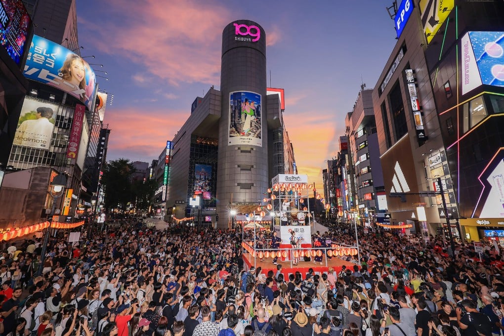 Locals and foreign tourists crowd the streets to watch a performance in the Shibuya district of central Tokyo in August. Photo: AFP