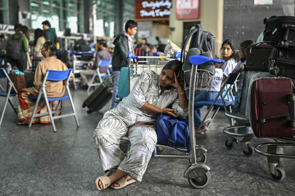 A passenger waits outside the IndiGo Airlines kiosk at the Kempegowda International Airport in Bengaluru on Saturday. Photo: AFP