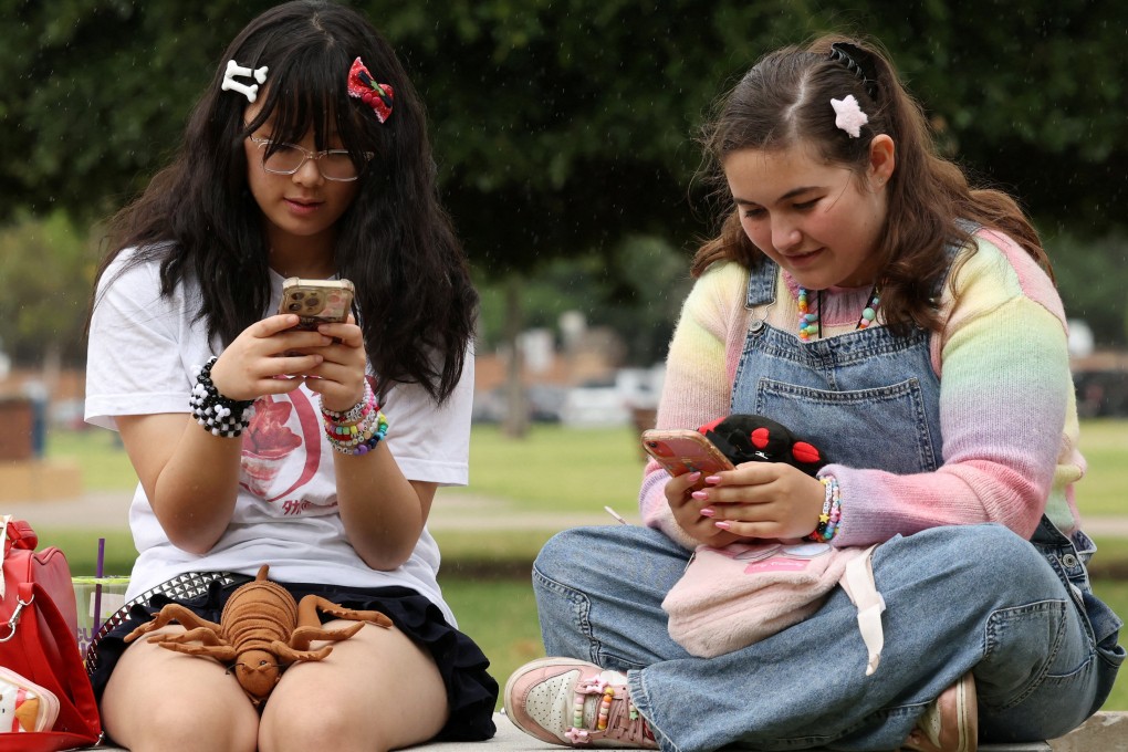 Australian teens Annie Wang (left), 14, and Ayris Tolson, 15, check their phones a few days before Australia’s social media ban for users under 16 is scheduled to take effect on December 10. Photo: Reuters