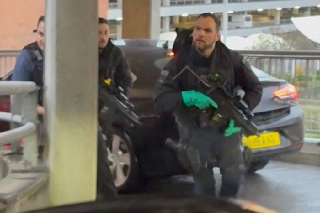 Armed officers respond at Heathrow Airport on Sunday, as seen through a car windscreen. Photo: Tom Bate via Reuters