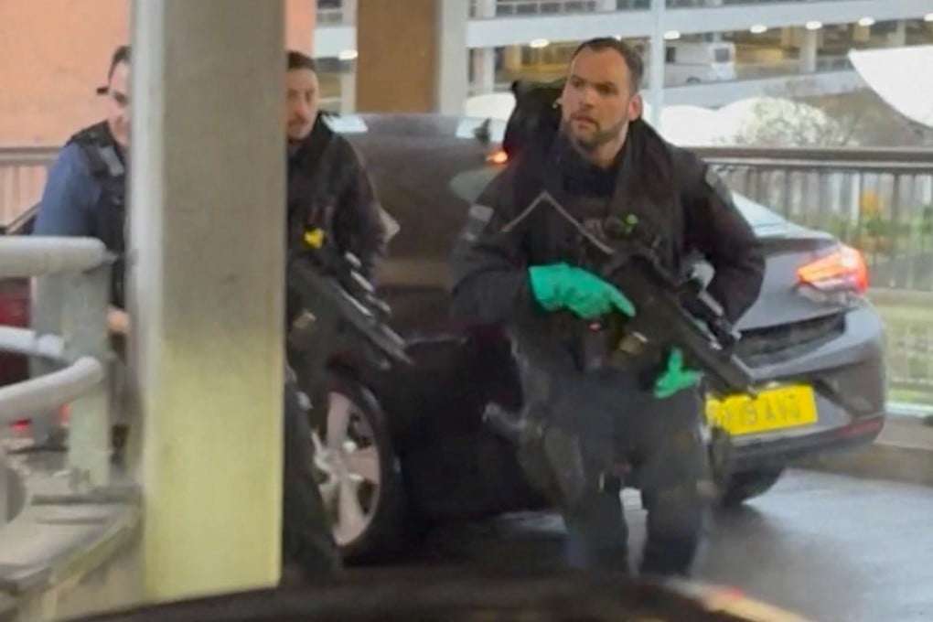 Armed officers respond at Heathrow Airport on Sunday, as seen through a car windscreen. Photo: Tom Bate via Reuters