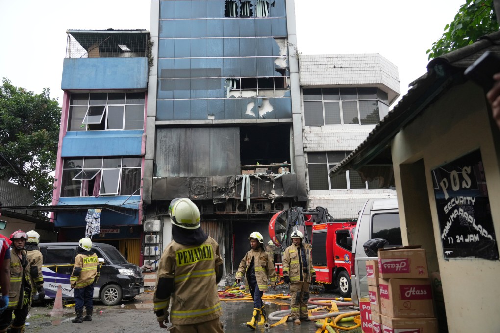 Rescuers work around an office building that caught fire in Jakarta, Indonesia on Tuesday. Photo: AP