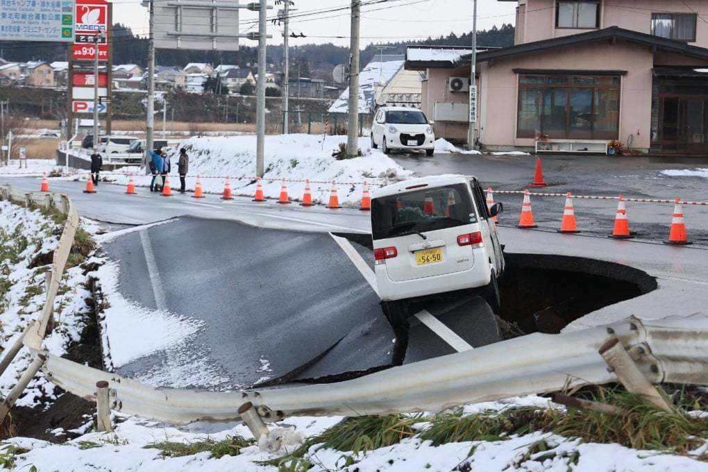A vehicle rests on the edge of a collapsed road in Tohoku town in Aomori Prefecture on Tuesday following a 7.5 magnitude earthquake. Photo: AFP