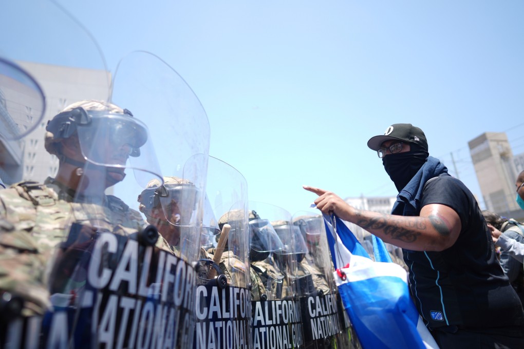 A protester confronts a line of US National Guard in downtown Los Angeles in June. Photo: AP