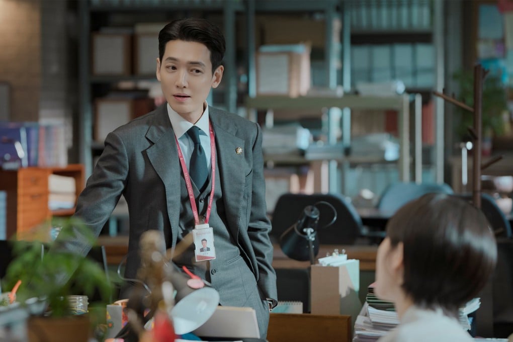 Ator Jung Kyung-ho interpretando o advogado Kang Da-wit em cena de Pro Bono vestindo terno elegante e braços cruzados
