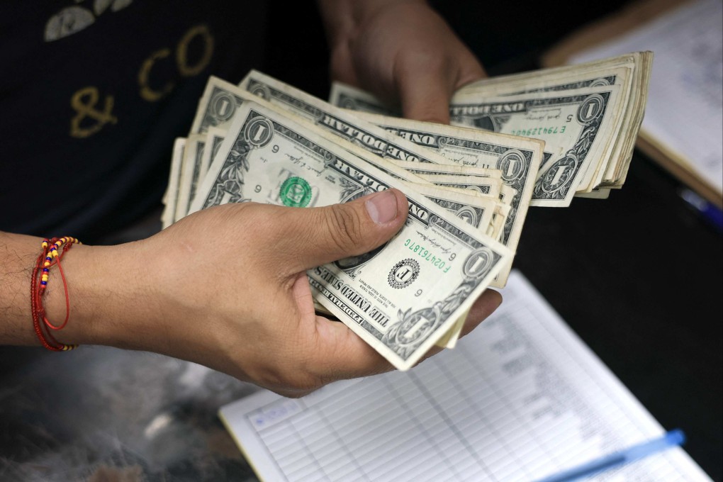 Money is counted at a fruit and vegetable store last month in Miami, Florida. Democrats claim tariffs have cost American households almost US$1,200 since Trump returned to the White House. Photo: Getty Images/AFP