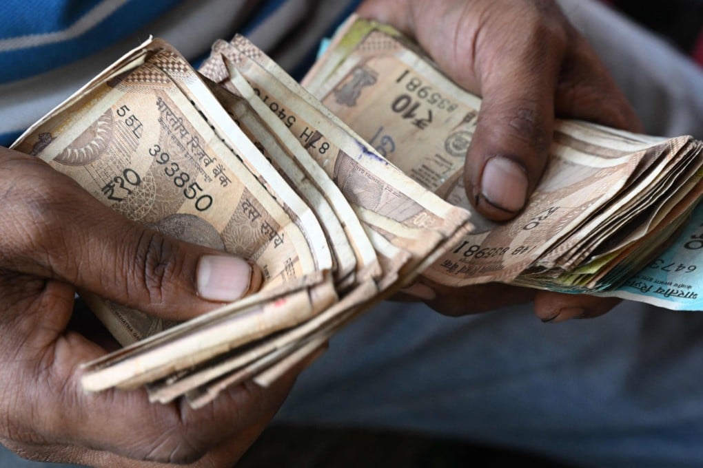A roadside vendor counts Indian rupee notes in Mumbai on November 28. Photo: AFP
