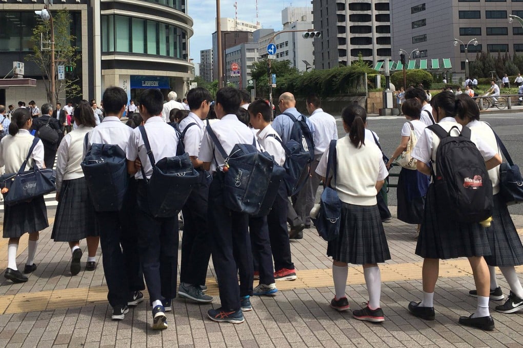 Japanese schoolchildren cross a street in Tokyo. English proficiency is dropping in Japan, a fact that some critics are attributing to outdated teaching methods. Photo: AFP