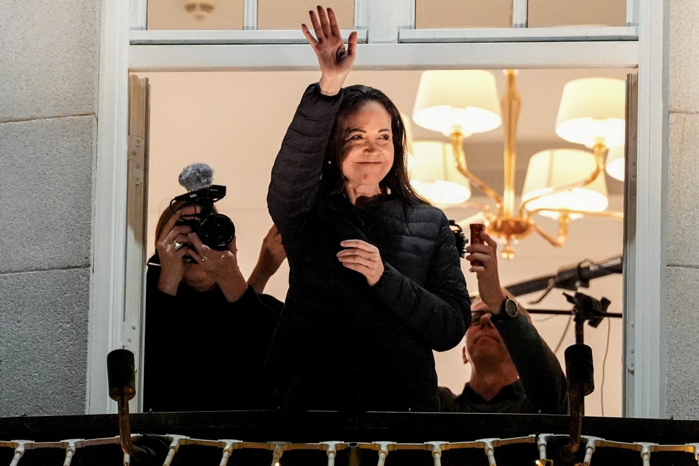 Maria Corina Machado waves from the balcony at the Grand Hotel in Oslo. Photo: Lise Aserud/NTB via Reuters