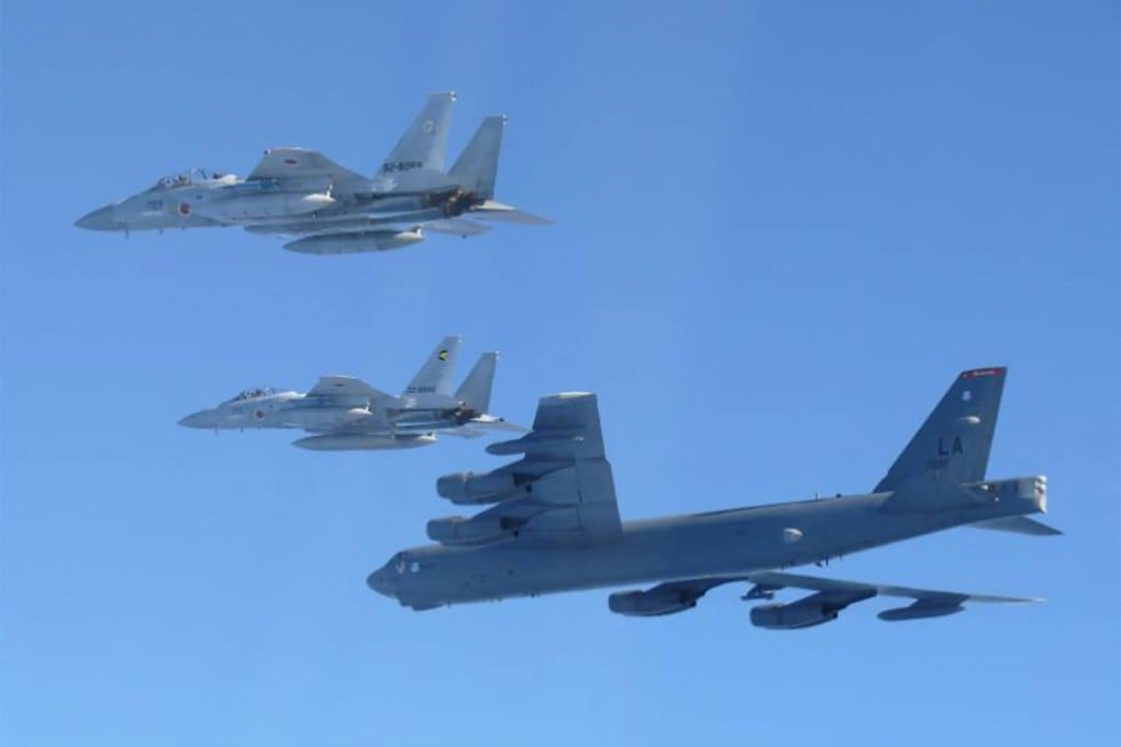 A US B-52 strategic bomber (bottom) and Japanese F-15 fighter jets take part in a joint exercise over the Sea of Japan on Wednesday. Photo: AFP
