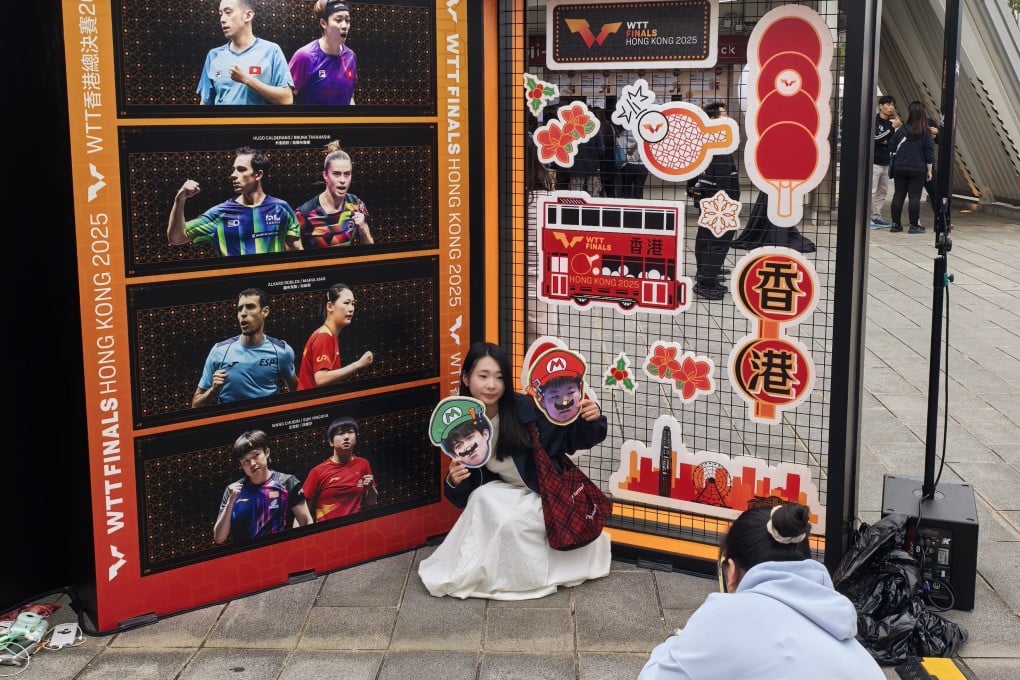 A fan of Wang Chuqin and Sun Yingsha taking photos with her idols as a backdrop. Photo: Ada Li