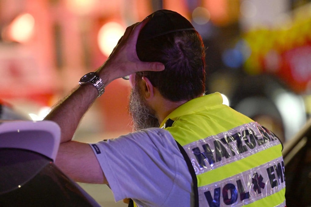 A member of Sydney’s Jewish community reacts as he stands near the site of a fatal shooting at Bondi Beach on Sunday. Photo: AFP