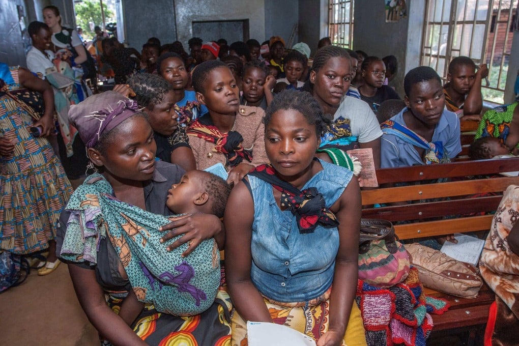 Mothers wait for their babies to receive a malaria vaccine in Malawi in 2019. Japan has slashed funding to a global health agency fighting infectious diseases. Photo: AFP