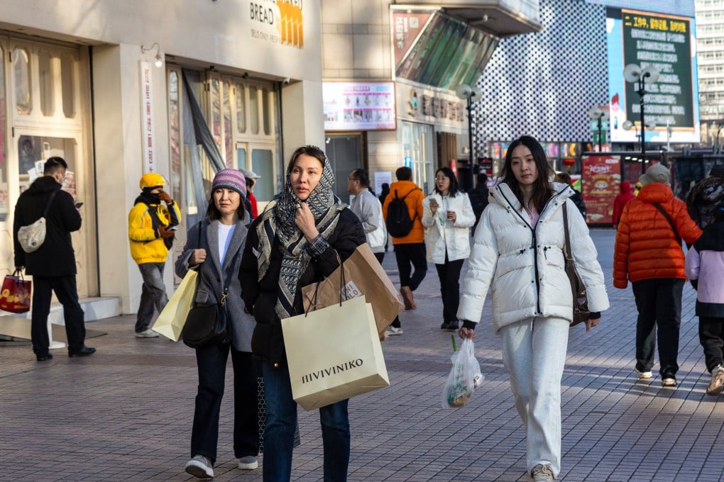 People walk through a shopping area in Beijing, on February 18. By breaking down local barriers, China aims to unlock the latent potential of its domestic market. Photo: EPA-EFE