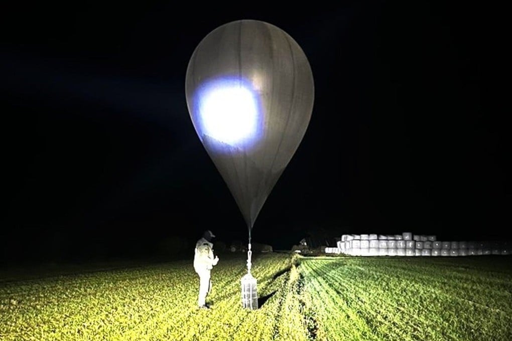 An undated image shows an officer inspecting a balloon used to smuggle cigarettes into Lithuania. Photo: State Border Guard Service via AP