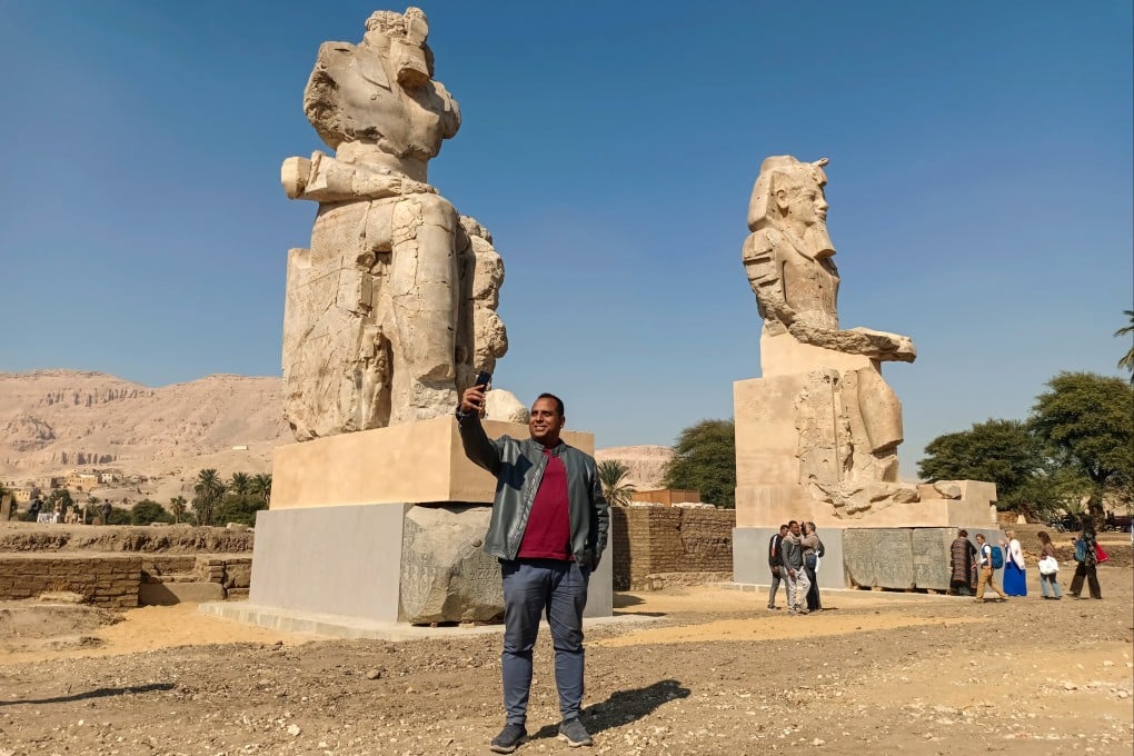 A man takes selfie in front of the two colossal statues. Photo: EPA
