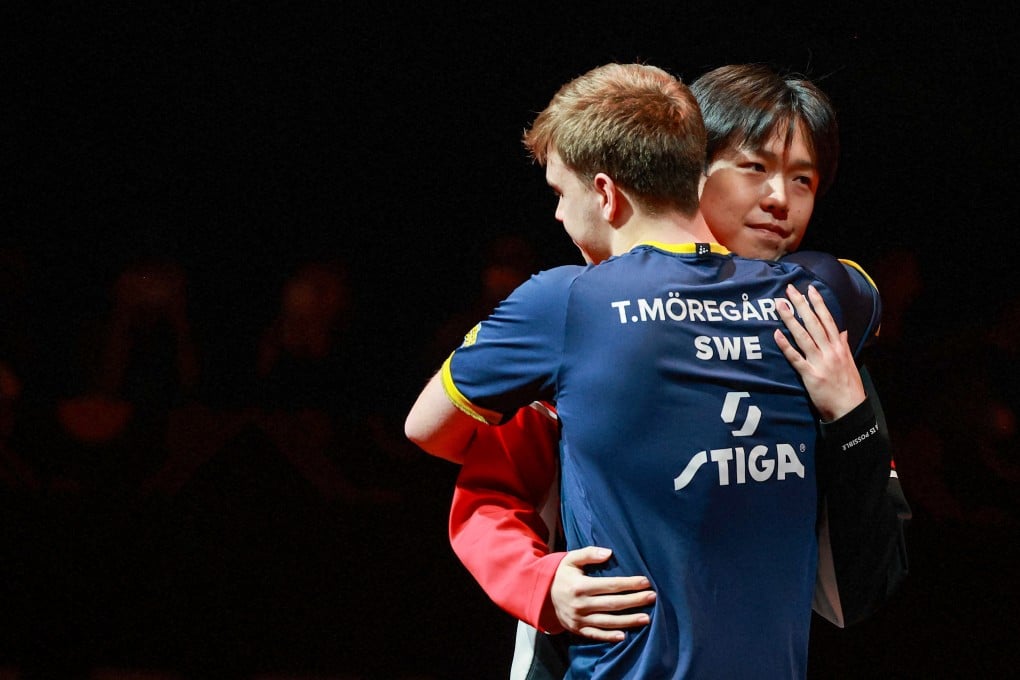 Wang Chuqin and Truls Moregard hug after it was announced Wang had pulled out of their semi-final. Photo: AFP