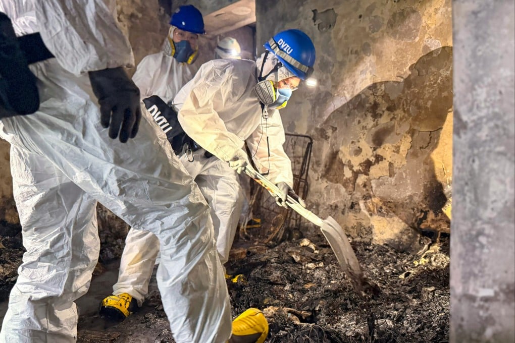 Officers of the Disaster Victim Identification Unit search the remains of a building destroyed in last month’s catastrophic fire in Tai Po. Photo: Handout