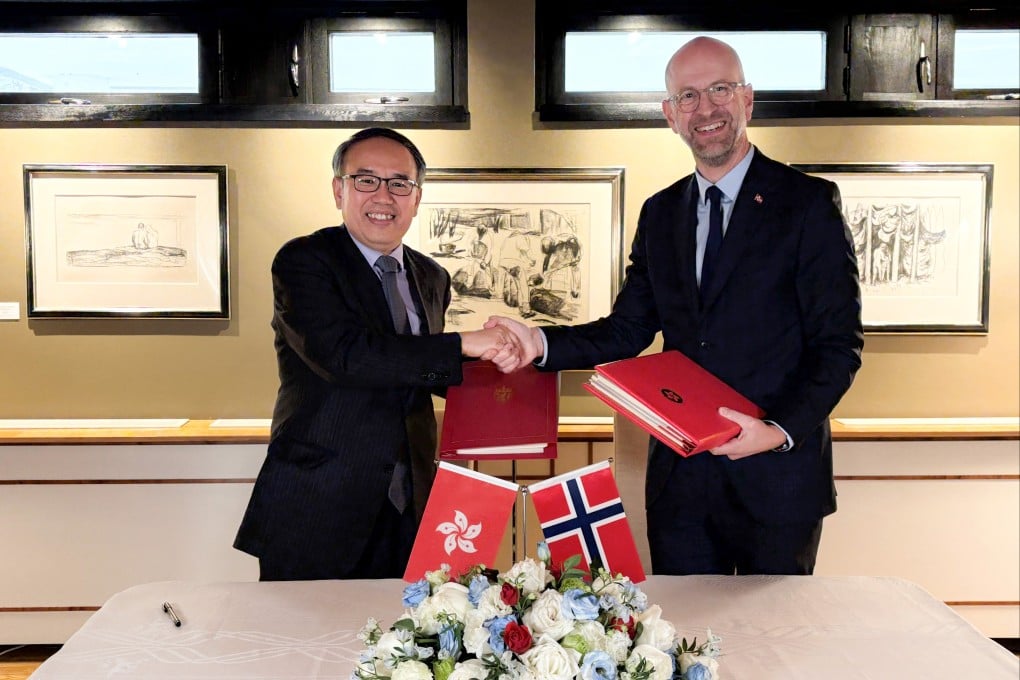 Hong Kong Secretary for Financial Services and the Treasury Christopher Hui (left), exchanges documents with Norway’s Ambassador to China, Vebjørn Dysvik, in Beijing on Tuesday. Photo: Handout