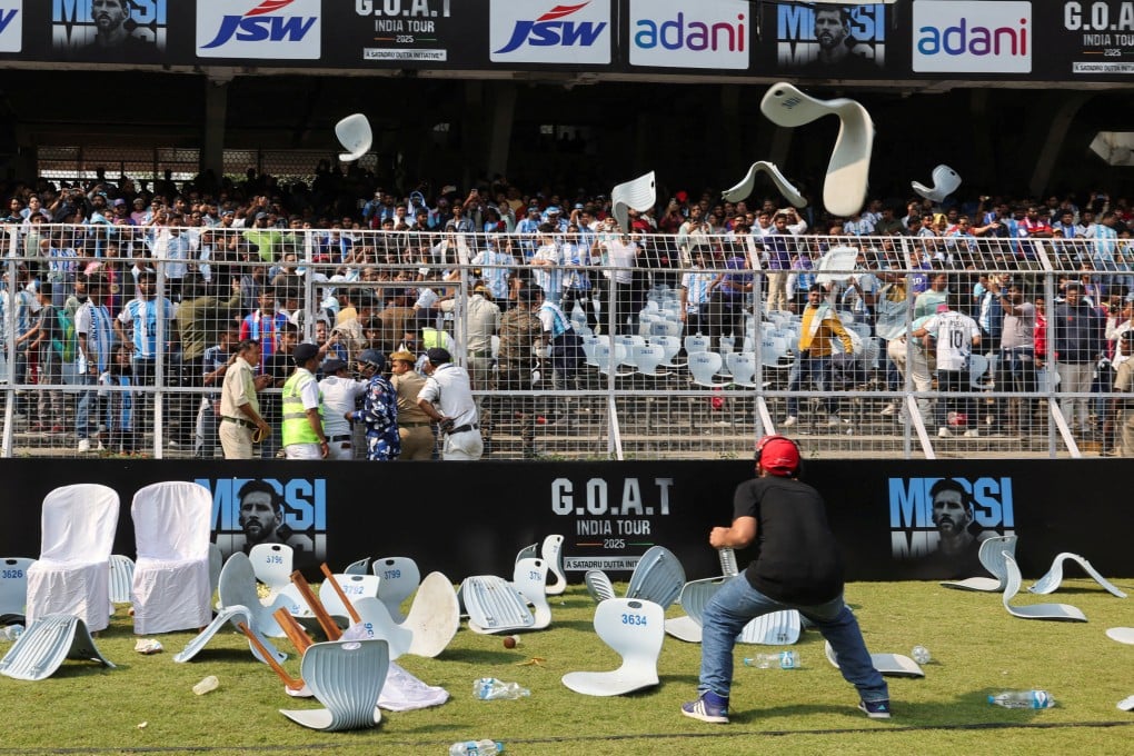 A man ducks to avoid chairs being thrown by fans after Argentine football star Lionel Messi leaves the Salt Lake Stadium during his tour in Kolkata on Saturday. Photo: Reuters