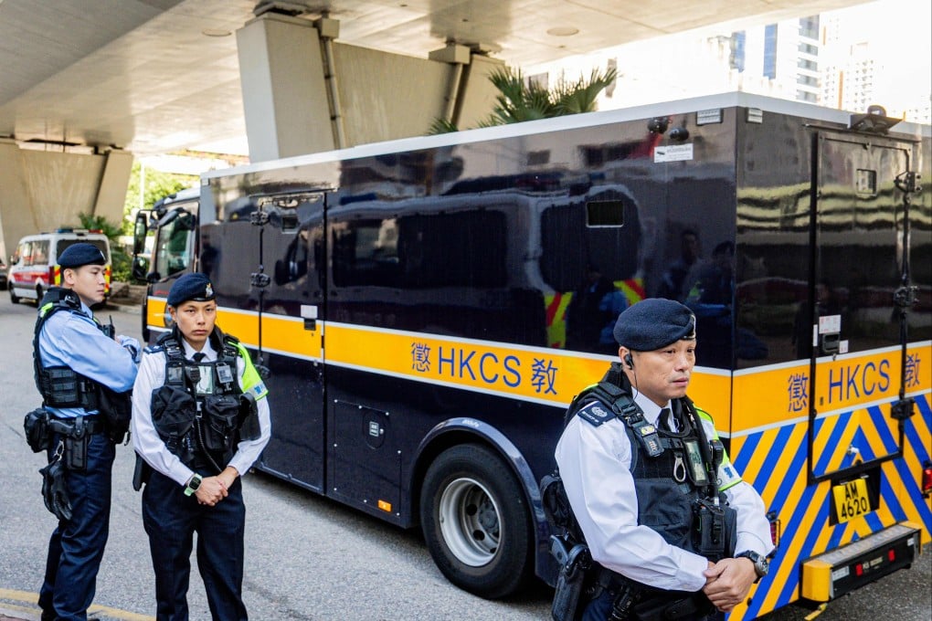 Police officers keep watch as a van transporting media tycoon Jimmy Lai leaves the West Kowloon court on Monday in Hong Kong. Photo: AFP