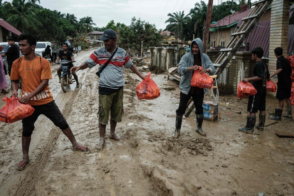 People unload aid supplies for distribution in Aceh Tamiang, Indonesia’s North Sumatra province, on Monday following heavy flooding earlier this month. Photo: AFP
