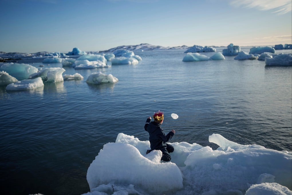 A boy throws ice into the sea in Nuuk, Greenland, in March. Photo: AP