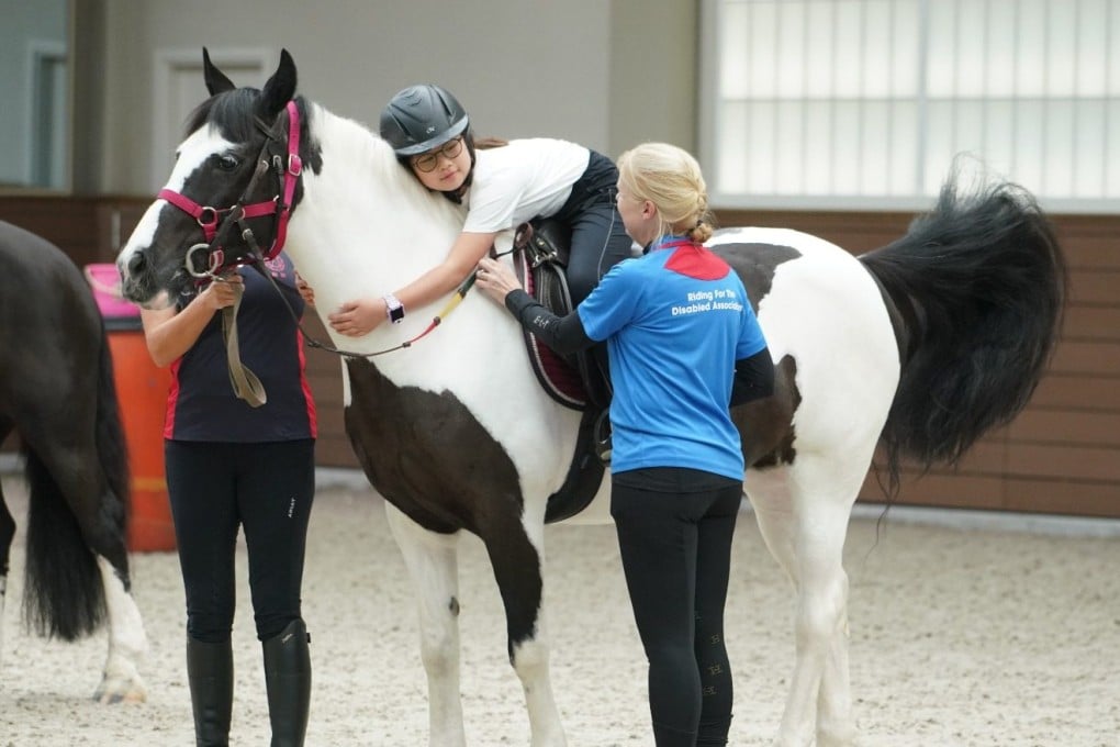 An instructor for Hong Kong’s Riding for the Disabled Association guides a child on a horse. The non-profit organisation teaches disabled children and some adults to ride a horse to the best of their ability. Photo: RDA