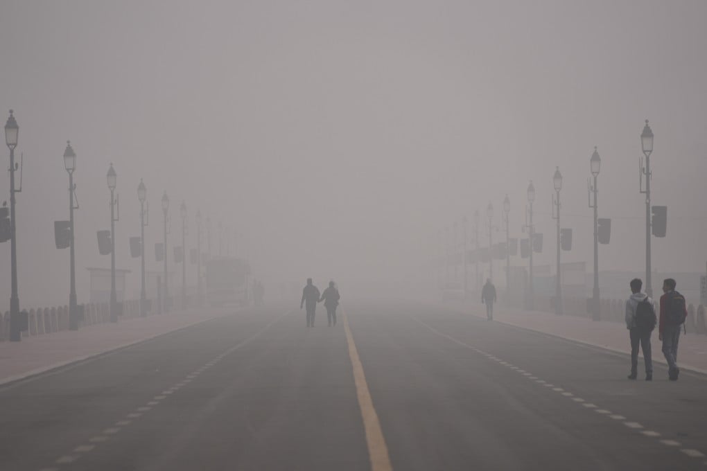 People walk through smog in New Delhi, India, on Monday. Photo: AP