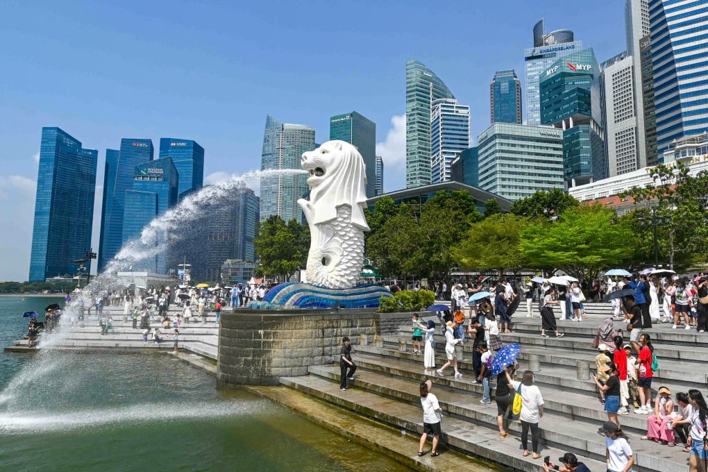 People take pictures next to the Merlion statue at the Marina Bay waterfront in Singapore. Photo: AFP